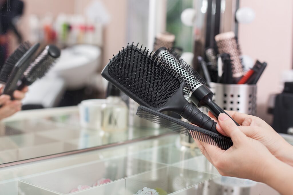 A woman hand holding three hair combs. hair brushes. hair styling