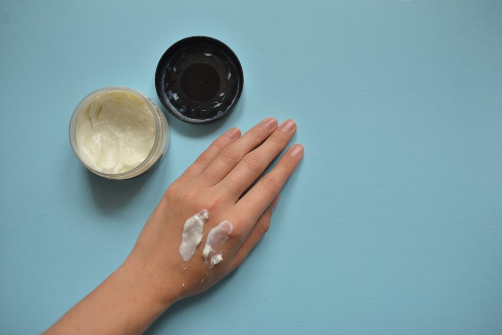 Texture and Absorption Rate. A woman hand with cream on it in a blue background