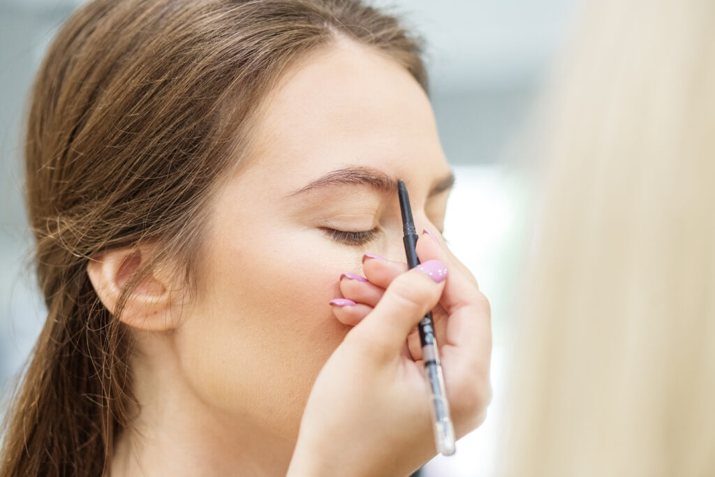 Professional make-up artist does make-up. Woman works in a hair salon. Small business. Make-up artist's workplace. eyebrow coloring techniques. Brow Pencil