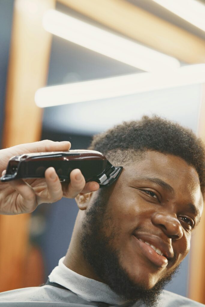 A man is getting his hair cut by a stylist in a salon.