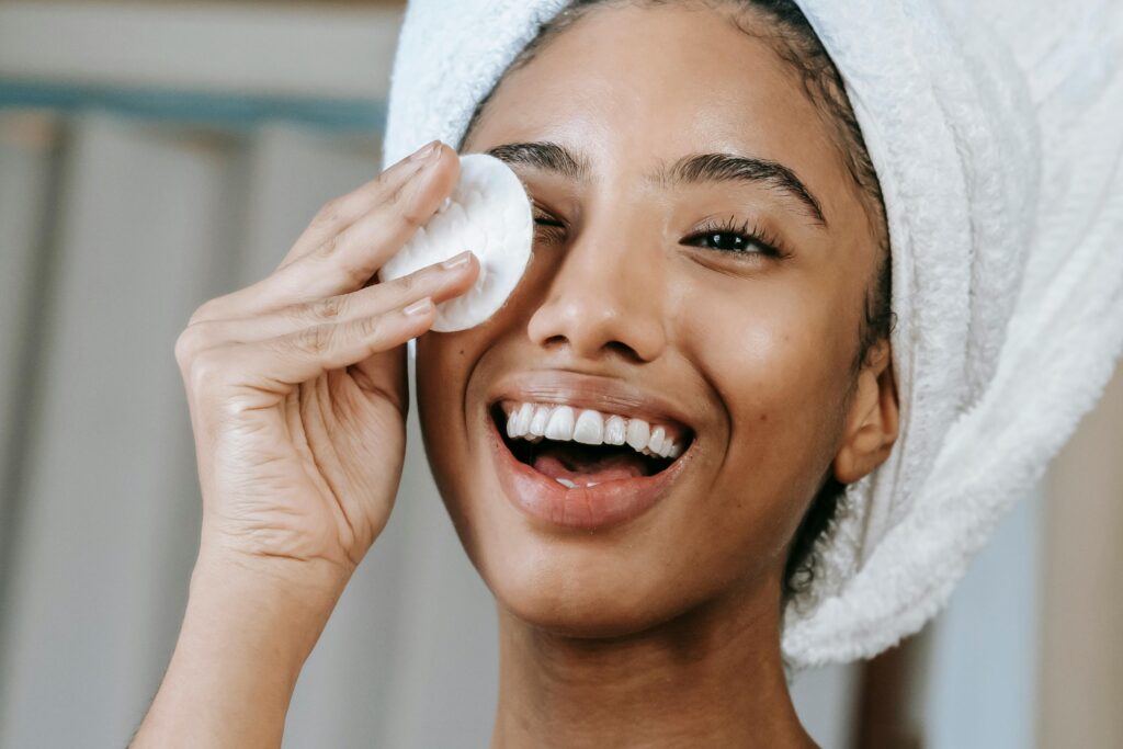 A smiling woman removing mascara