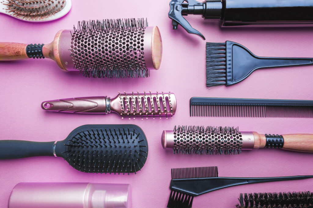 Choosing the Right Hair Brush. Various hair dresser and cut tools on pink background with copy space.