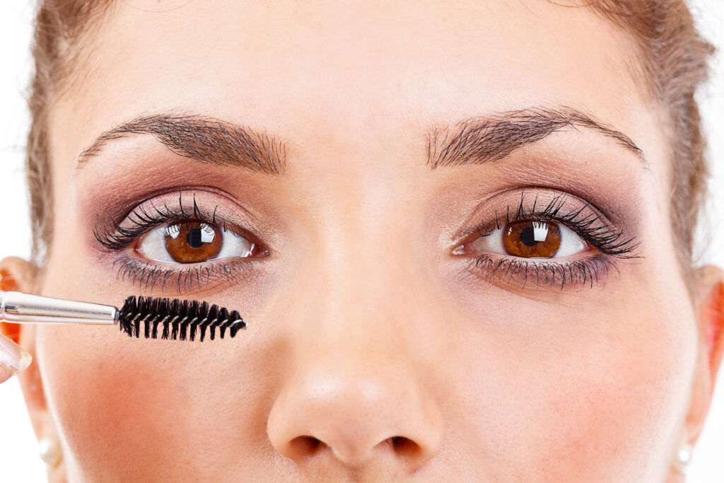 Woman applying lash definition on her long eyelashes