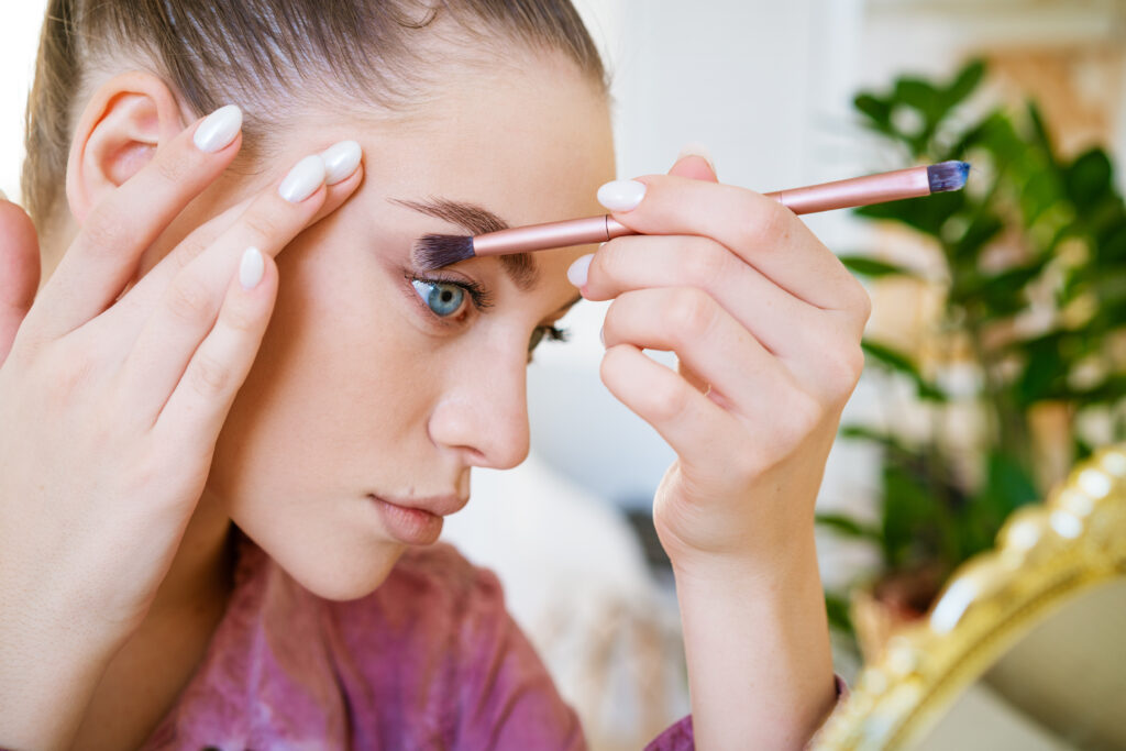 Young attractive female blogger talking about beauty. Shows how to apply makeup correctly. A female video blogger is recording an online self-care video course for her new lifestyle blog.