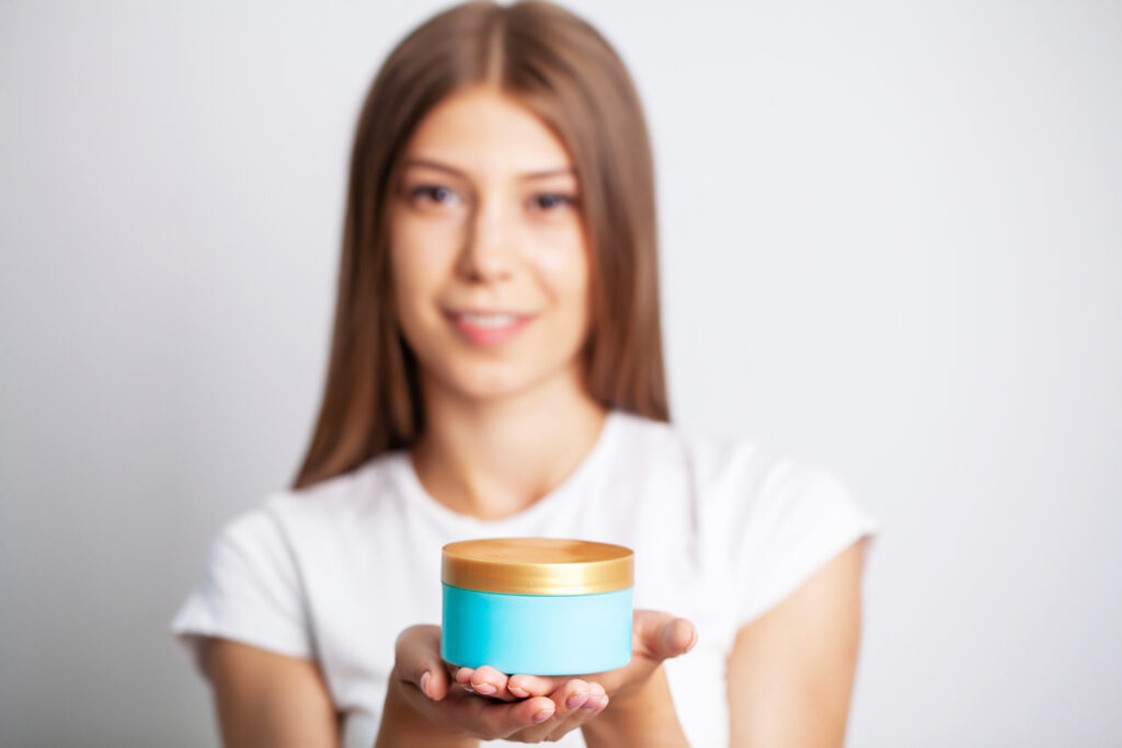 Young woman holding a jar of skin care cream. hair treatment. hair care