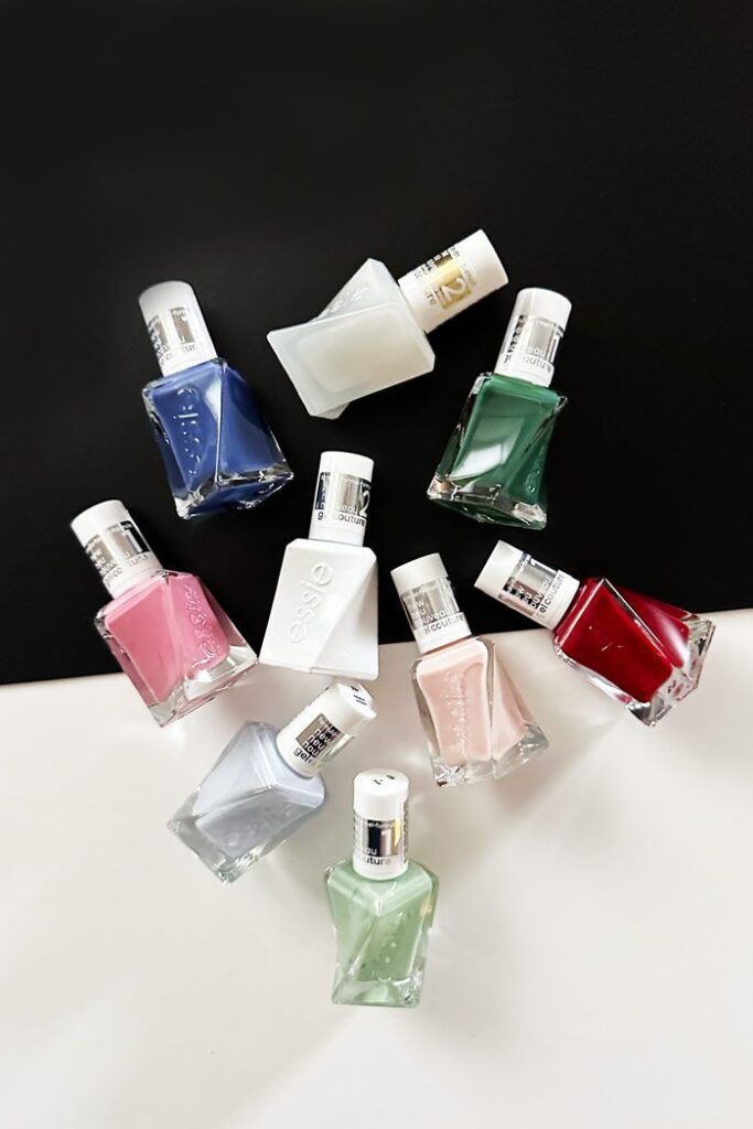 Essie Gel Couture gel polish bottles in various shades displayed on a black background.