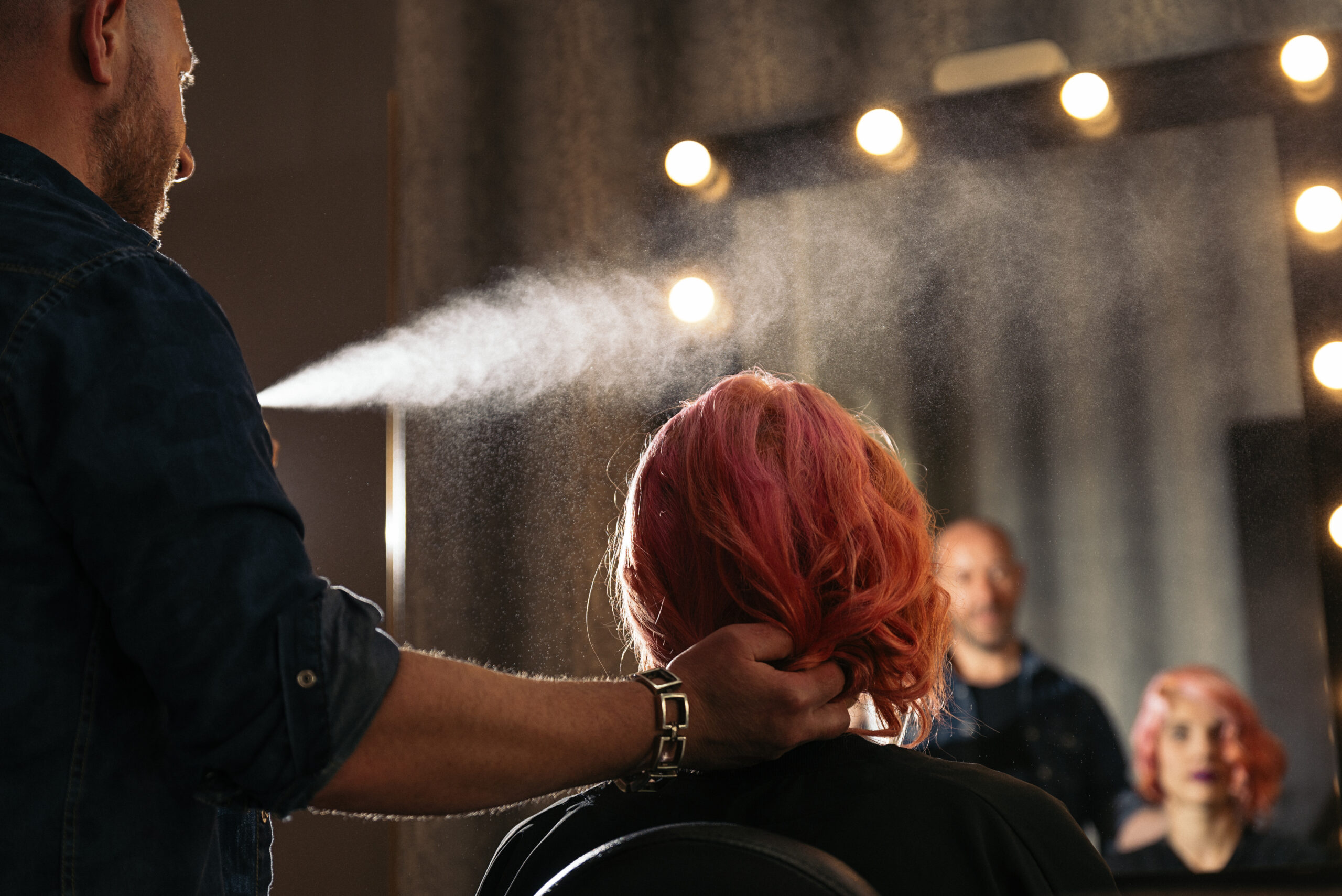 Beautiful woman getting haircut by hairdresser in the beauty salon. Hair care. Heat protection. Heat hair protection.