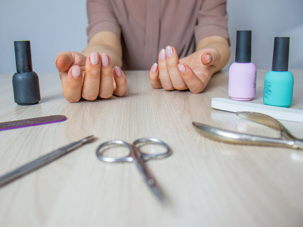 Home manicure tools. A female is doing her nails at home. DIT nails. Nail tools. Nail care products.