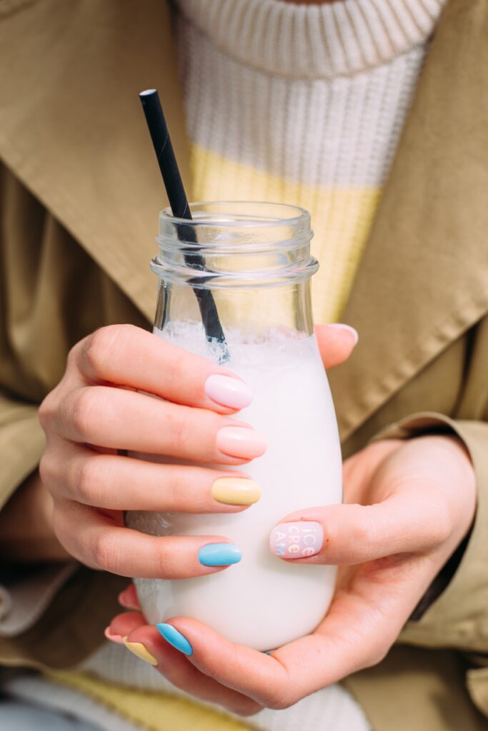 A woman nails painted in different gel polish color. Long lasting manicure. Nail polish. Colorful nails.