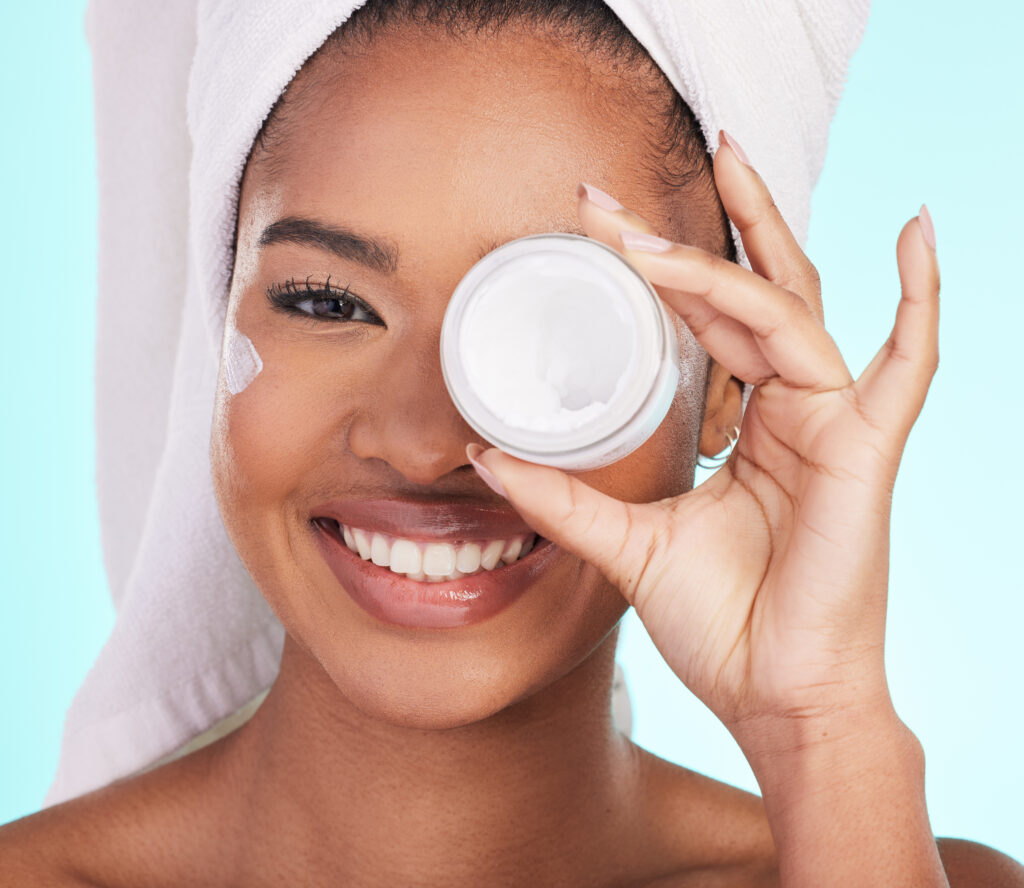 Black woman, jar and cream in studio portrait with smile for skincare, wellness or self care. eye care. eye masks. home eye care. DIR eye caring.