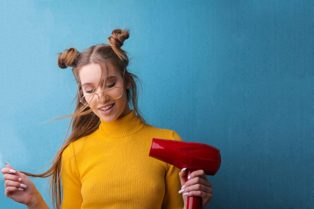 everyday hair styling. long hair. long brown hair. hair styling. blue background. hair dryer.