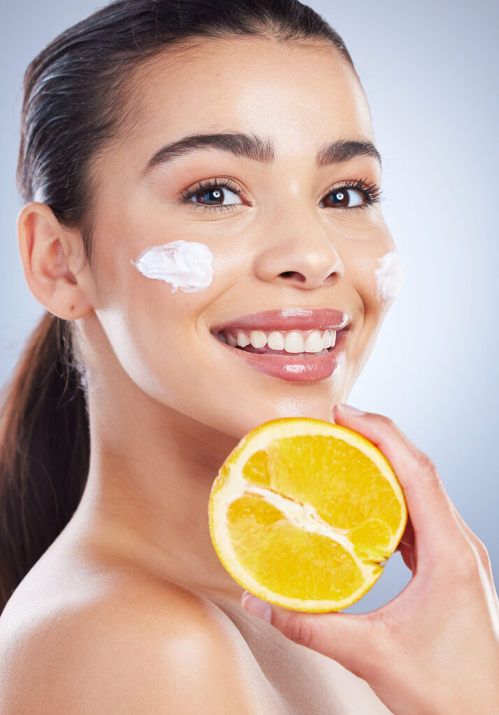 Lemon, skincare and woman portrait with face cream in studio for wellness or cosmetic mask on grey.