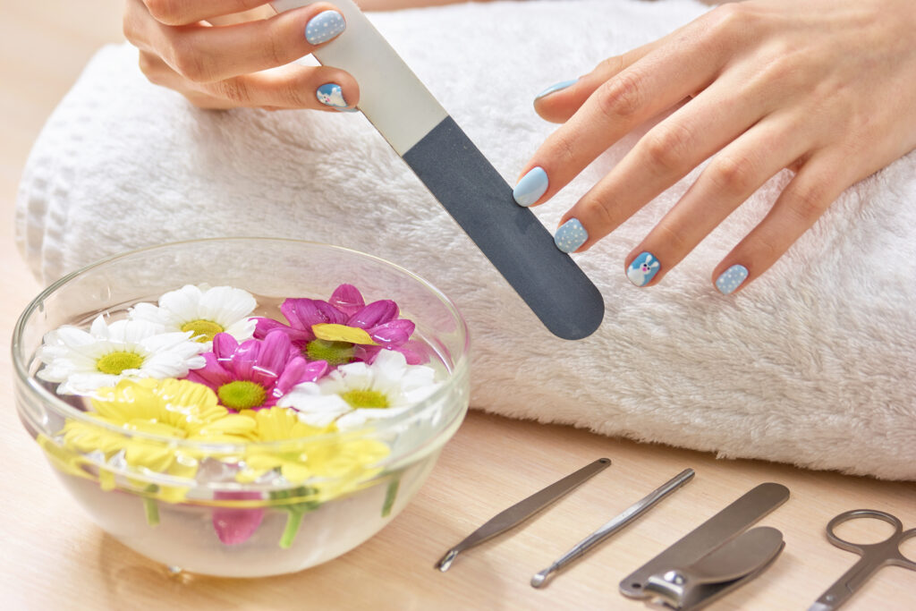 Woman in nail salon receiving a manicure. Close up of beautiful female hands having spa manicure at beauty salon. Woman hand care. home nail care. diy nail care.