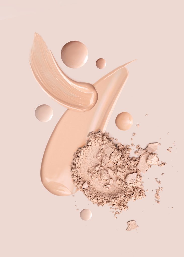 cosmetic smear foundation cream powder on a beige background