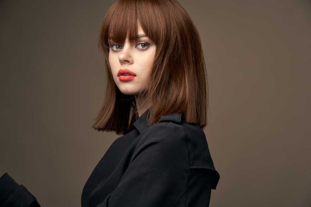 Attractive lady European appearance black coat Isolated background. Growing Out Short Hair