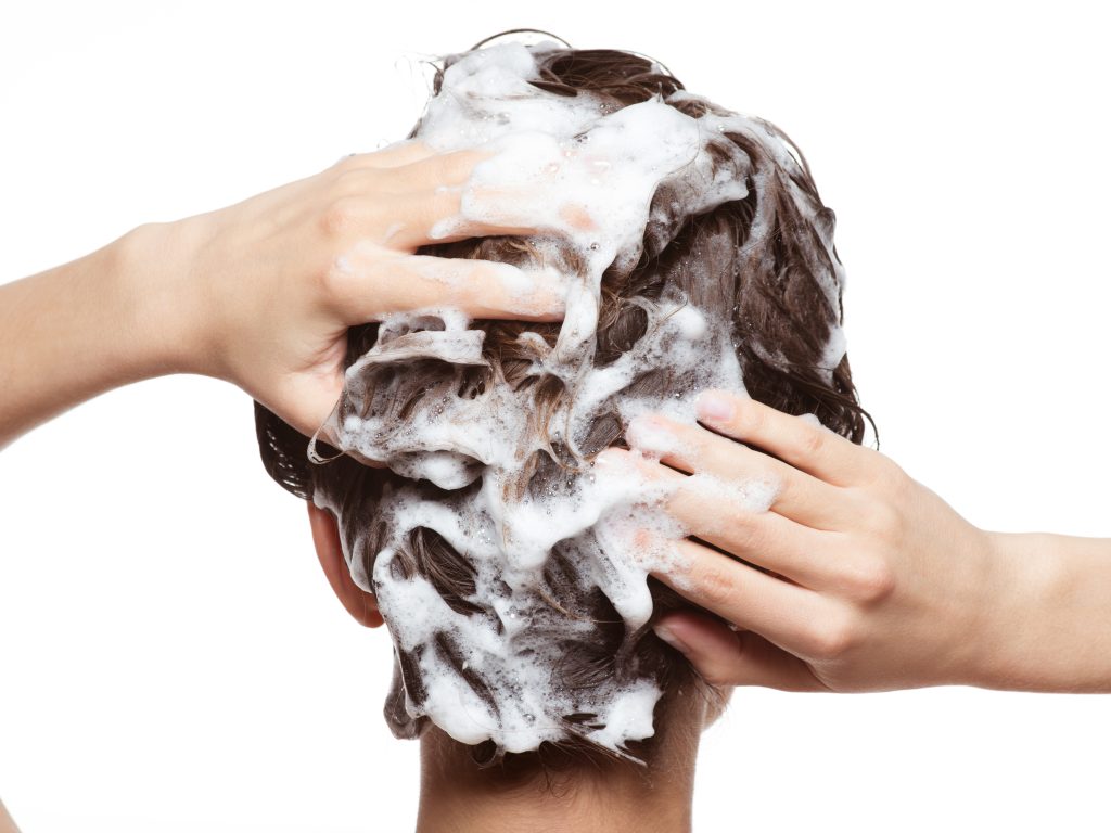 Woman soaping the hair. Beauty treatment - isolated on white background