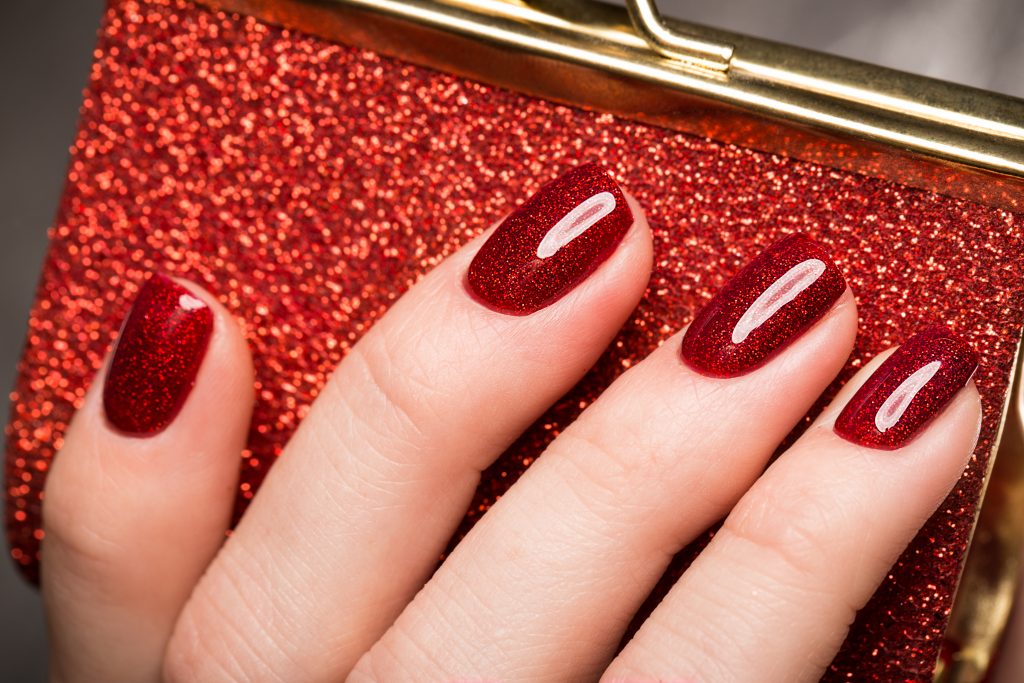 Bright festive red manicure on female hands. Nails design.