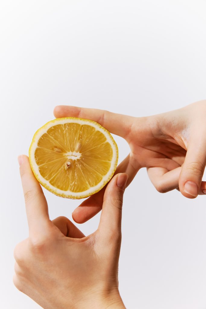 Hand holding a half of lemon on a white background with copy space for text or logo. perfect image for food and beverage related designs. Home Remedies to Treat Yellow Nails