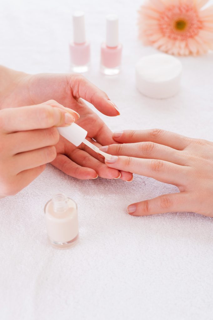 keep your nails healthy and strong. Making manicure. Close-up of beautician doing manicure to female customer. 