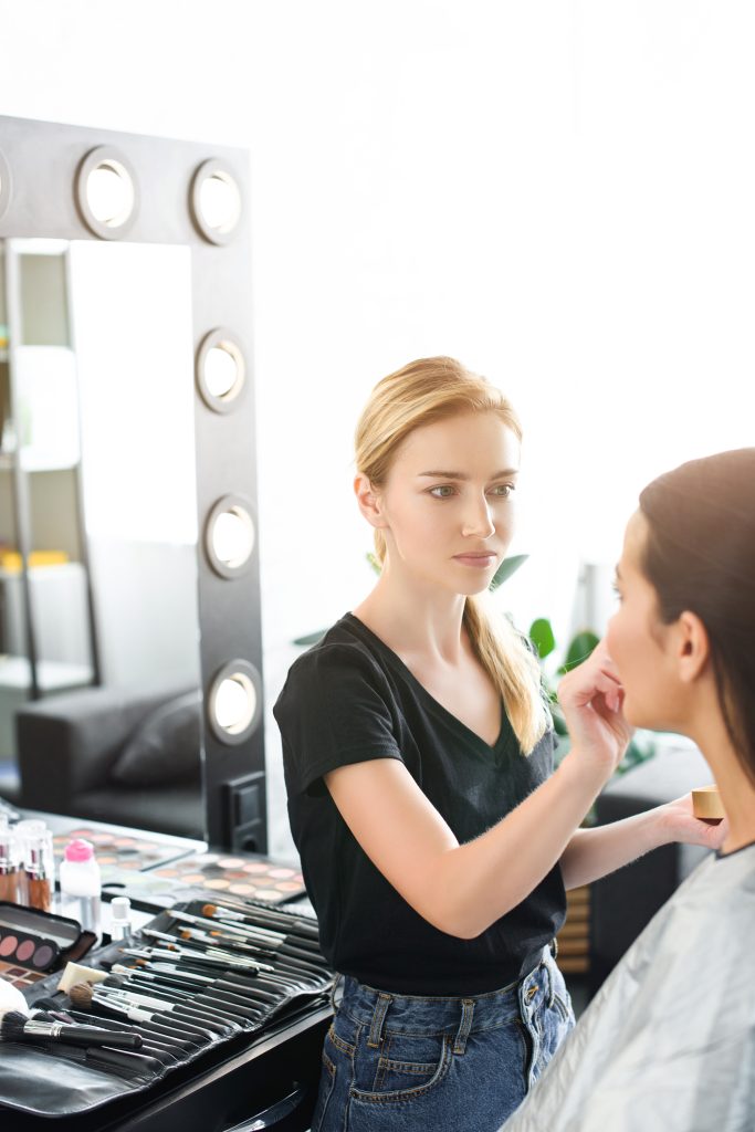 Makeup Courses in Canada. Career Opportunities After Completion. selective focus of young woman getting makeup done by makeup artist.