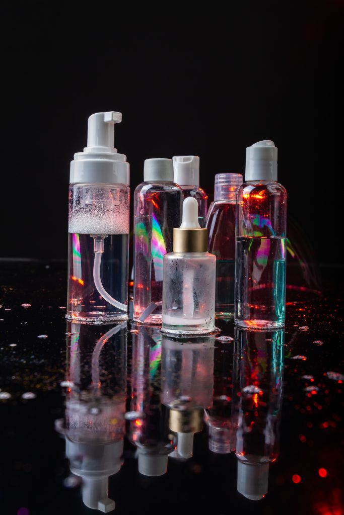 Set of cosmetic bottles on dark background. Verical shot close up. Top Ingredients for Overnight Skin Transformation.