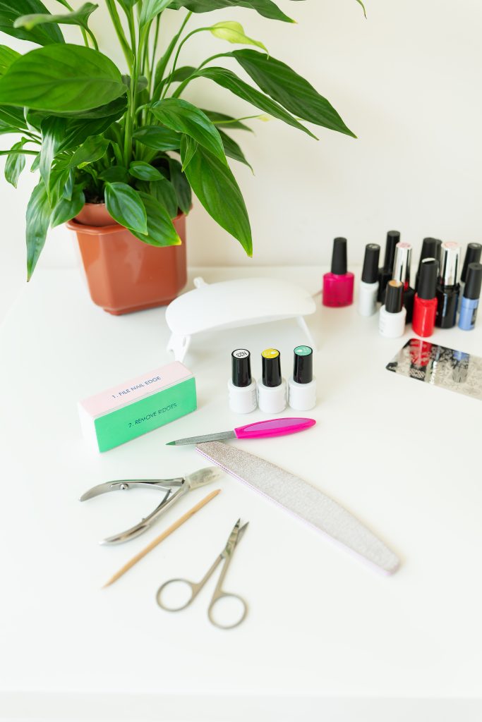 Recommended products and routines for nails. The concept of the workspace of the master of the nail salon. Top view of manicure tools on a white table. Cosmetic procedures and hand care.