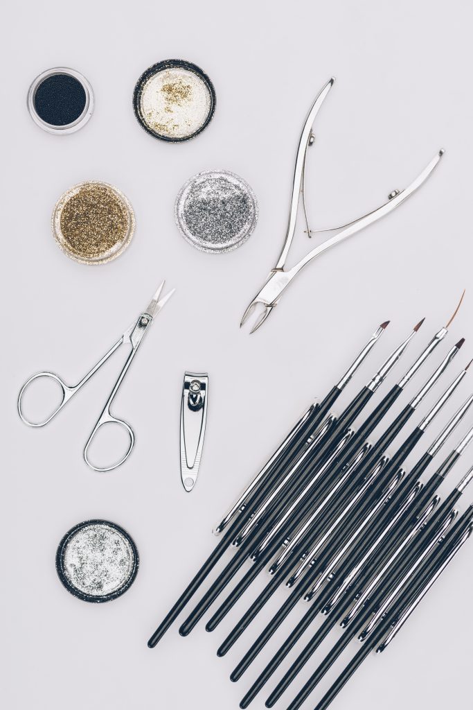 top view of glitter and manicure tools isolated on white. Essential Tools for New Year Nails.