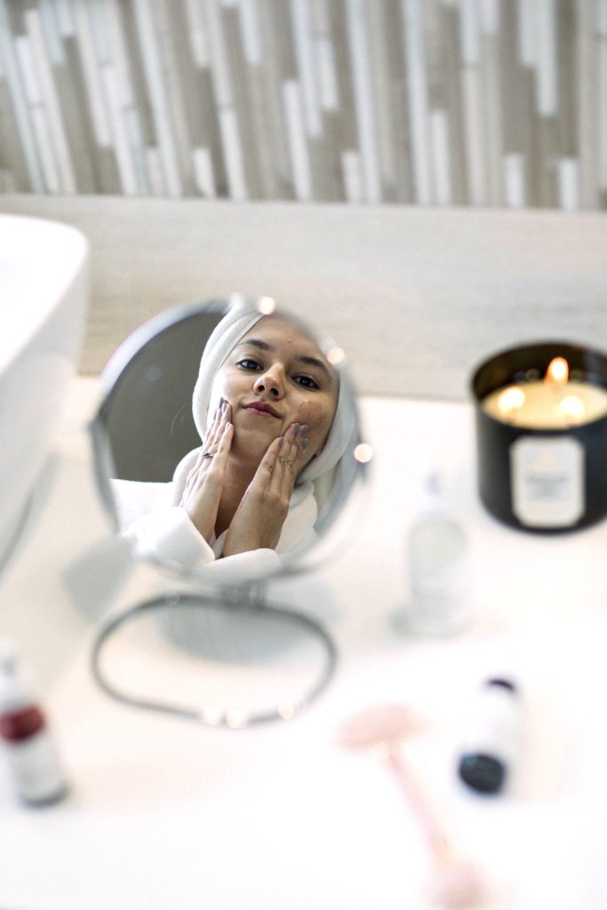 young woman applying face mask and getting ready. Step-by-Step Night Skincare Routine.