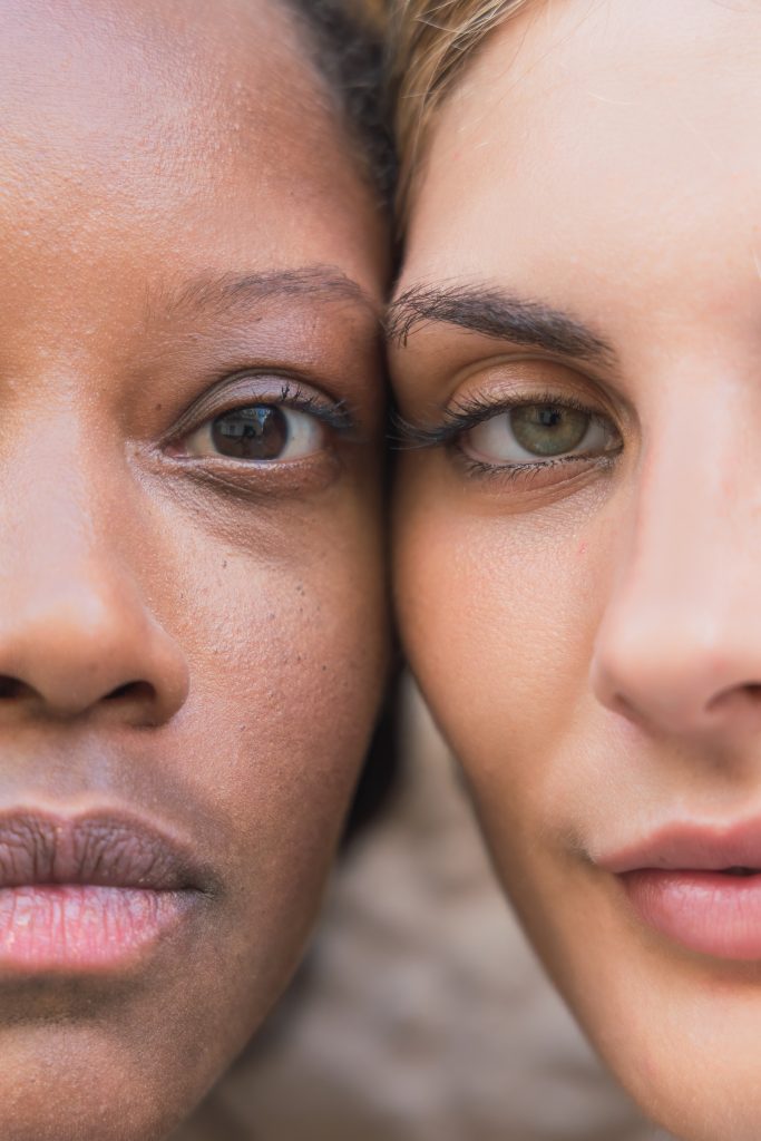 Closeup halves of faces of tranquil diverse girlfriends with clean skin looking at camera. Best Ingredients to Look For.