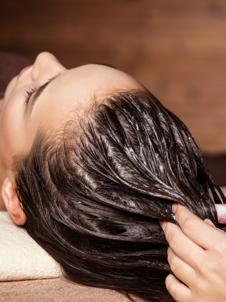 Cosmetologist massaging hair on the head of the woman. hair treatments. Beauty treatment.