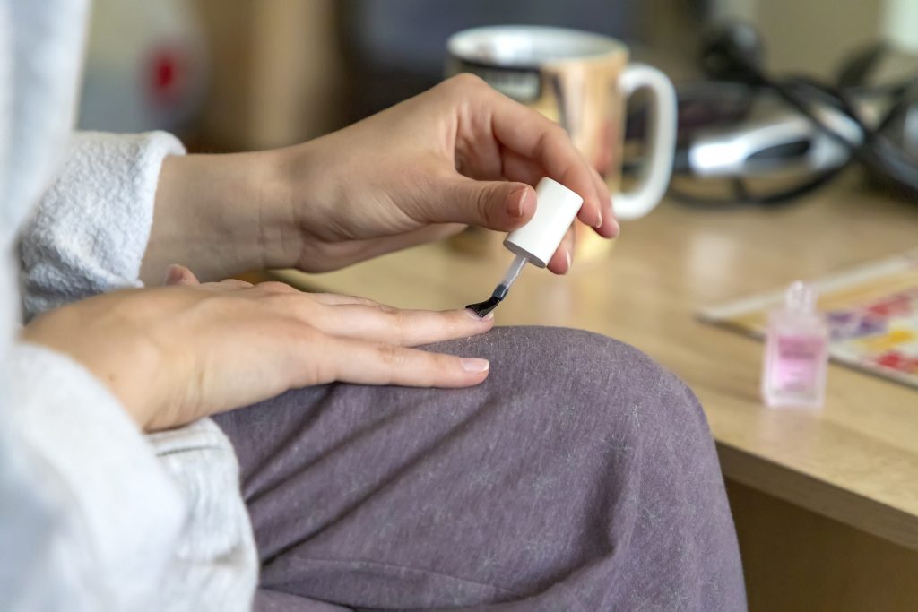 Young woman makes herself manicure at home