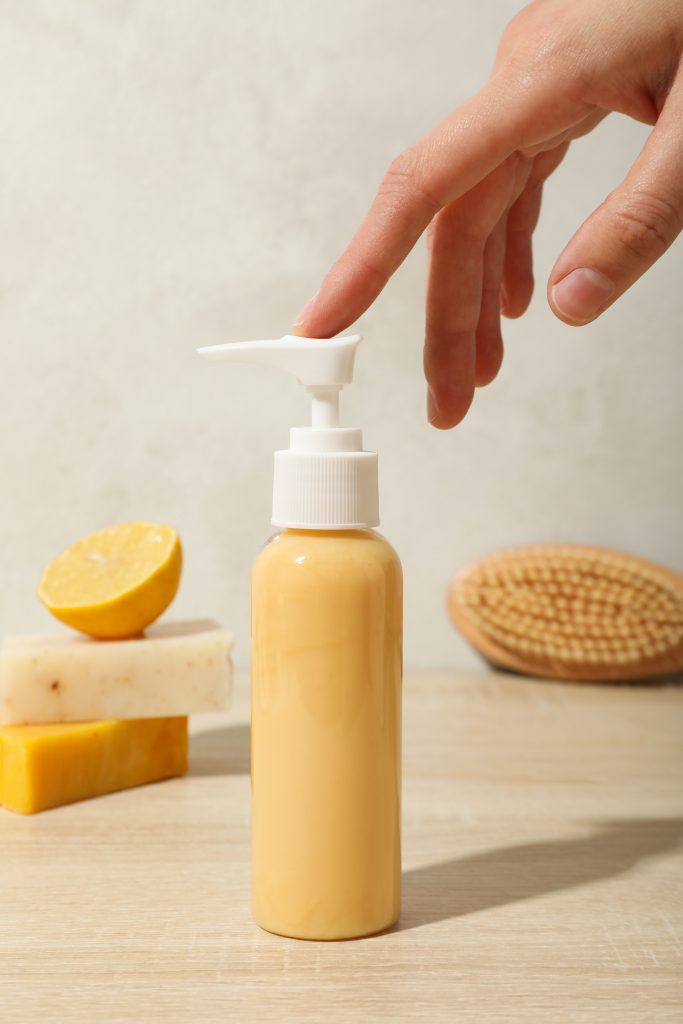 Soap, lemon, brush, hand and bottle of soap on beige background. hair cleaner. Lemon and hair brush.