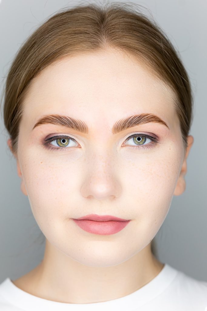 Adding Color to Your Brow Lamination. the face of the blonde model and the finished procedure lamination of eyebrows eyebrows combed with the help of long-term styling.