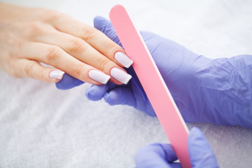 Woman hands in a nail salon receiving a manicure procedure. SPA manicure.