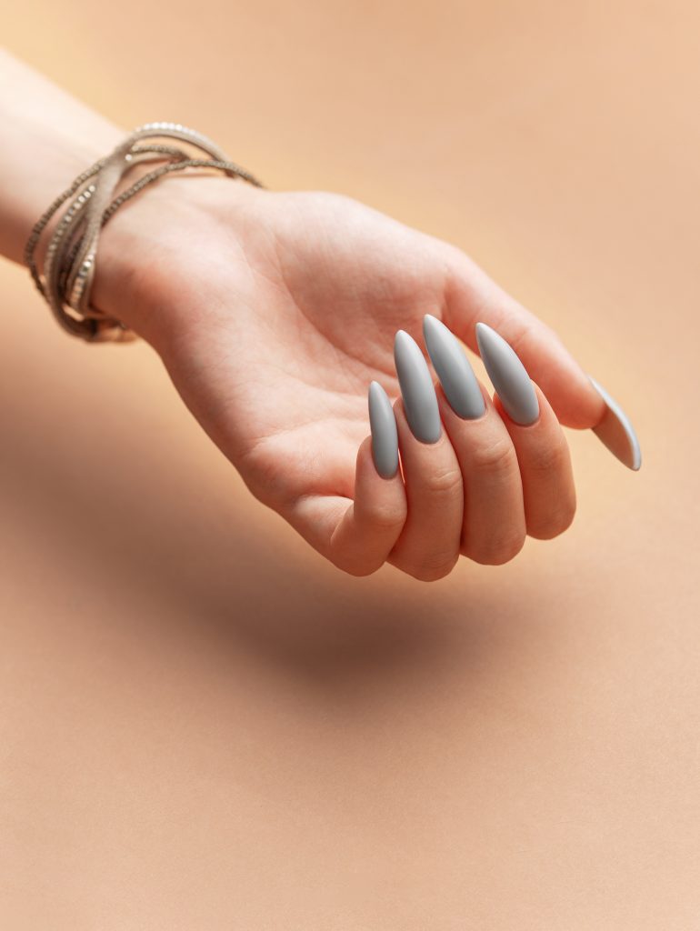 Close up of woman's hand with grey nail polish