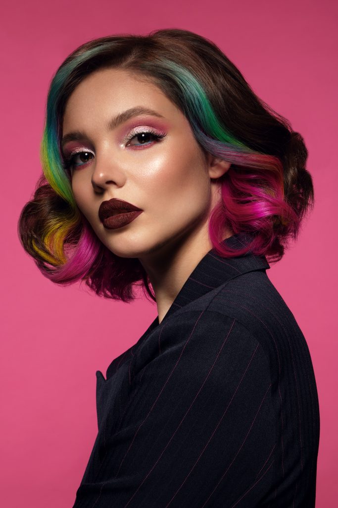 Portrait of beautiful woman with multi-colored hair and evening make-up and hairstyle. Beauty face.