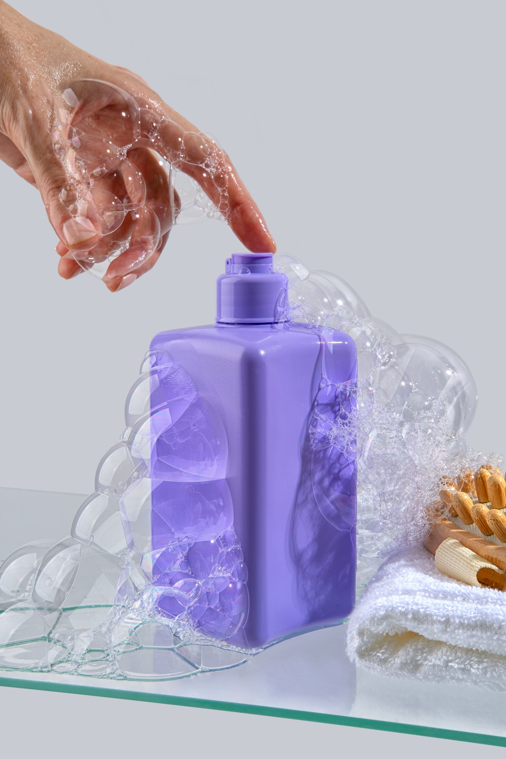 Cosmetic product in a purple jar, shower gel, face wash, shampoo or liquid hand soap stand on a glass shelf on light background. Moisturizing and cleansing concept. Set of accessories for hygiene. Natural organic spa cosmetic concept, minimalism brand packaging mock up. hand soap. hand care.