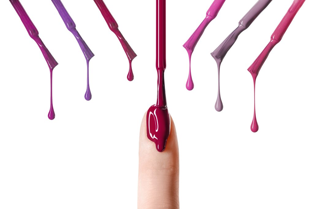 messy drop of pink nail polish dripping on nail isolated on white