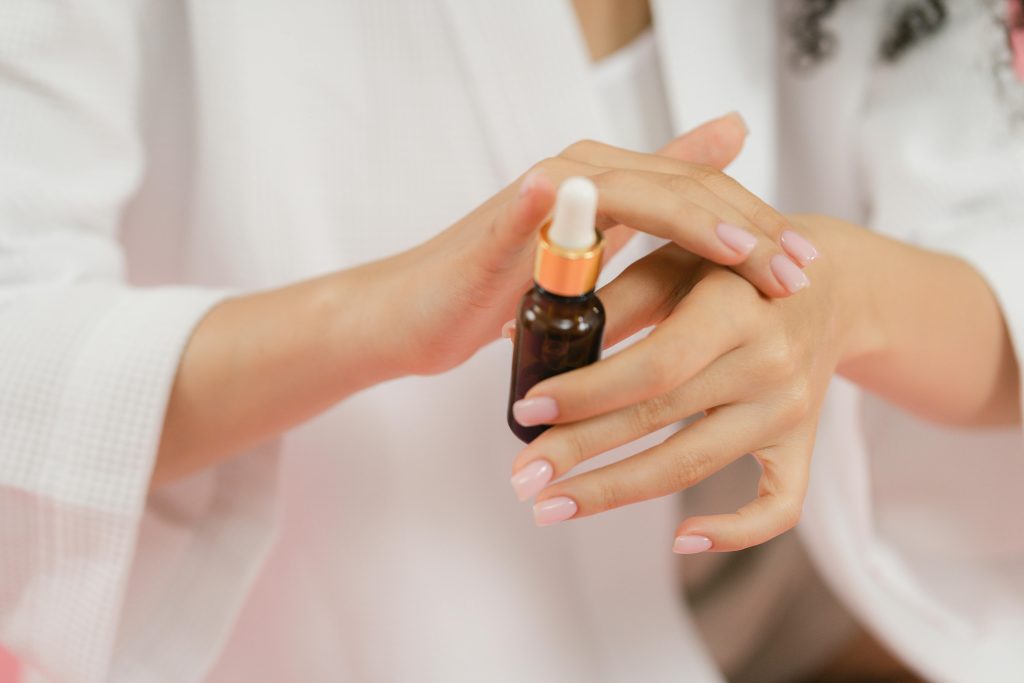 A faceless woman apply nail treatment. nail care.
