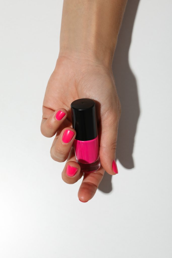 Pink nail polish with a woman's hand. Keep Nail Polish from Peeling.