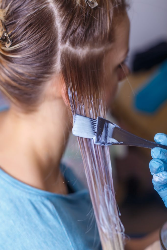 Professional hairdresser dyeing hair of her client. Hair Color Last Longer. 