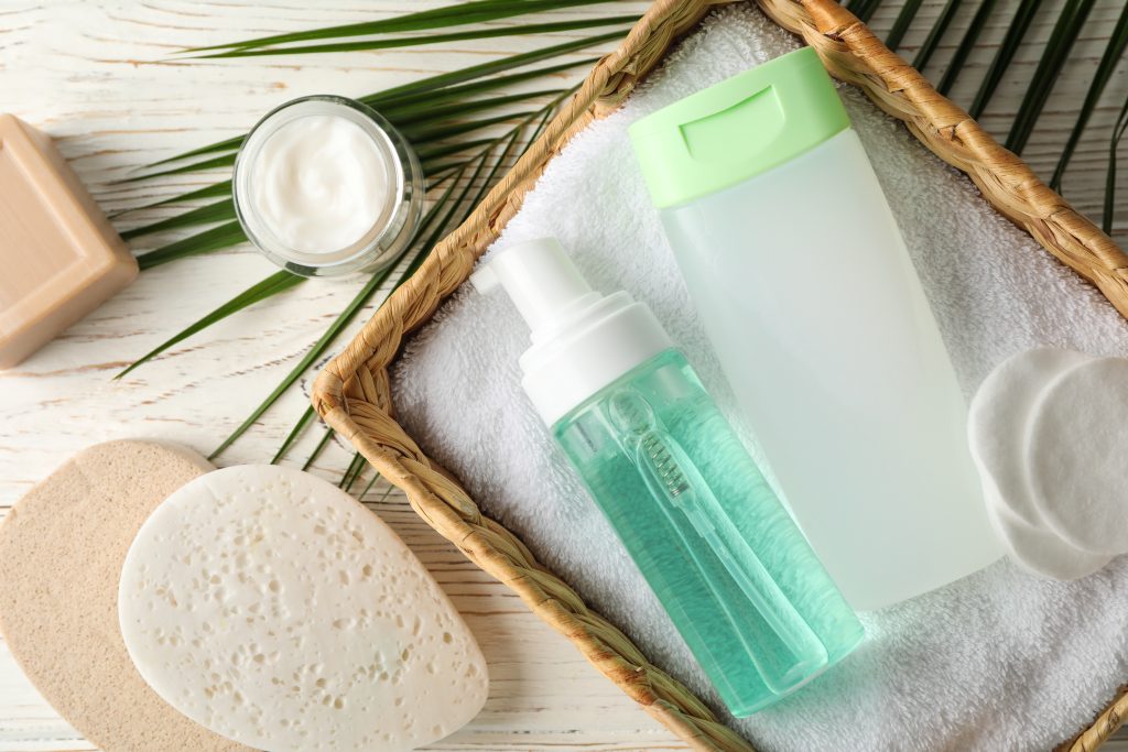 What Is Body Shower Gel? Bottle of hair shampoo and fresh organic coconut , natural cosmetic on light orange background