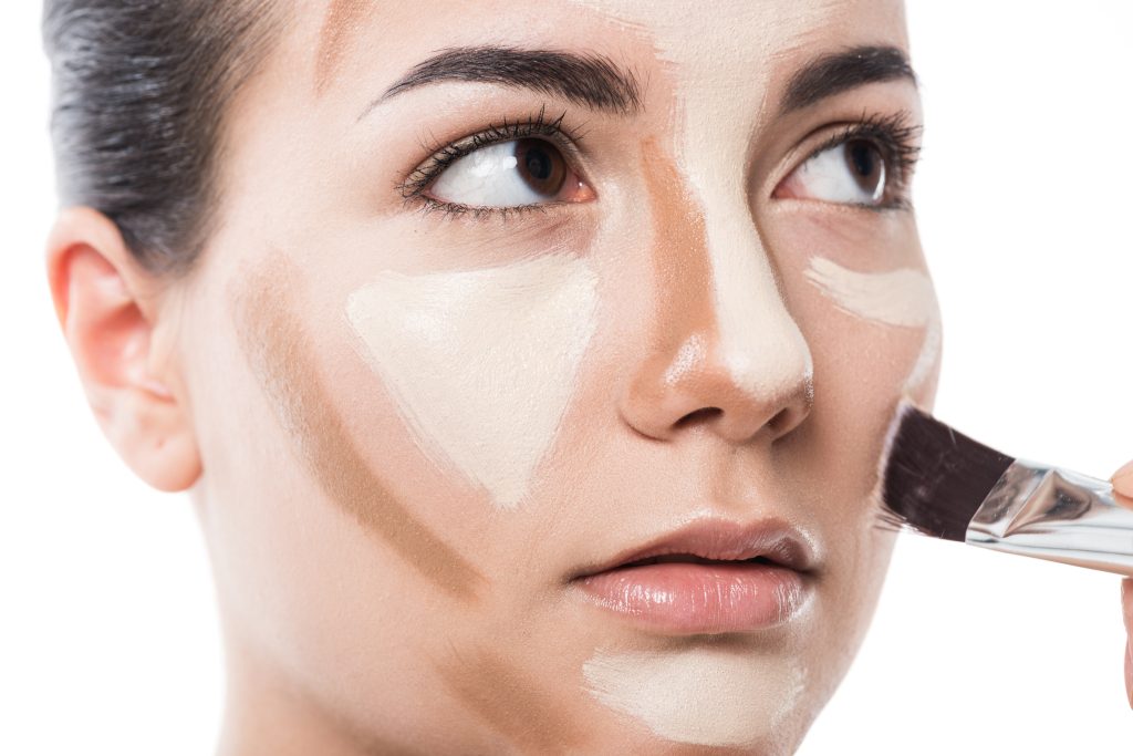 cropped image of visagiste doing makeup for girl isolated on white. avoid Concealer Mistakes.