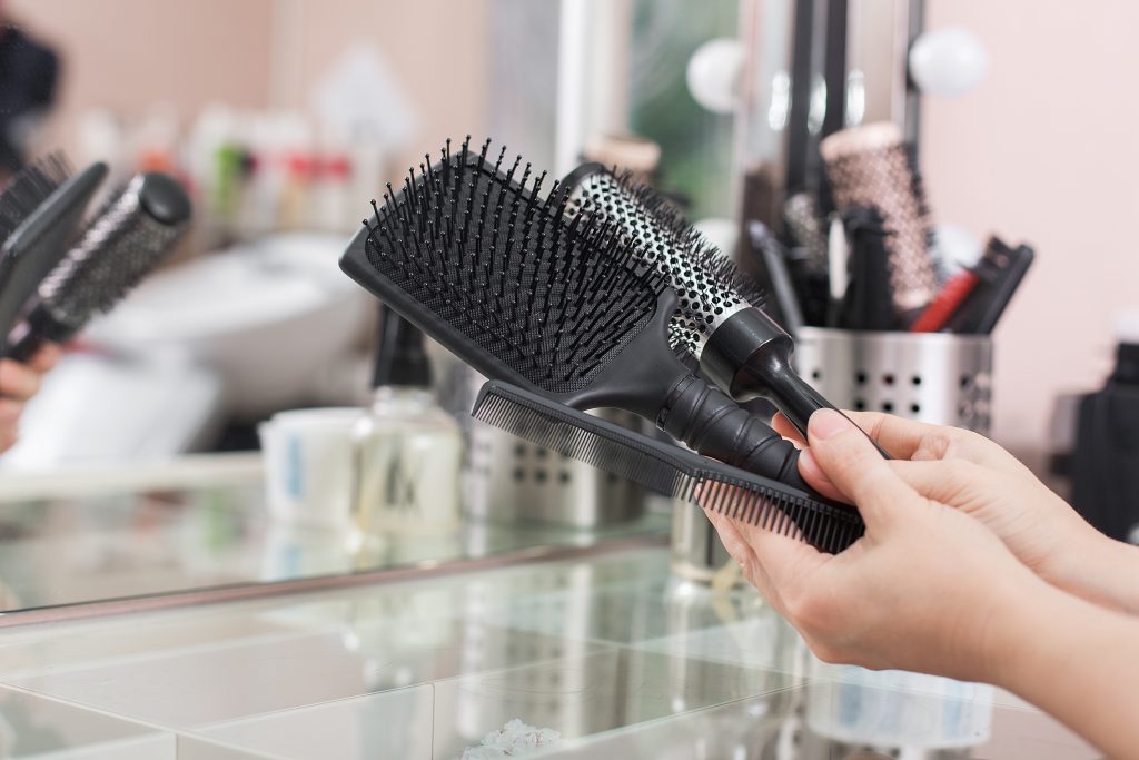 hair brushes. hairdresser holds in hand three hair combs