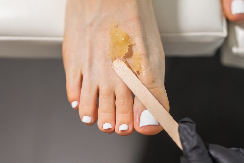 Peeling feet pedicure procedure in a beauty salon. Sugar scrub and relax beauty procedure. foot scrubs. feet scrubs. heel scrubs.