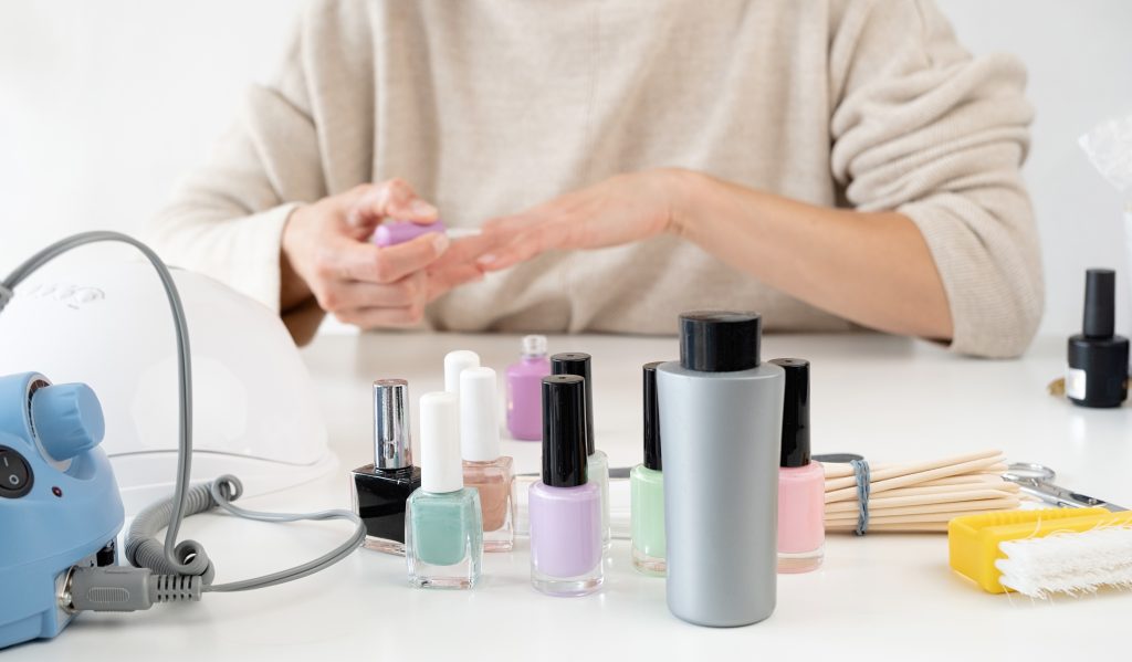 woman doing manicure with nail polish, Manicure at home for yourself. A woman's hand with healthy natural nails. procedure of nail care.