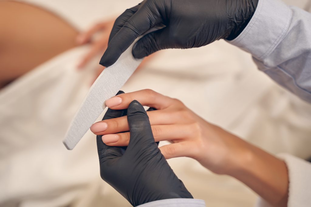 Experienced manicurist carefully shaping client nail form while using professional file. So, Which One Is Right for You?
