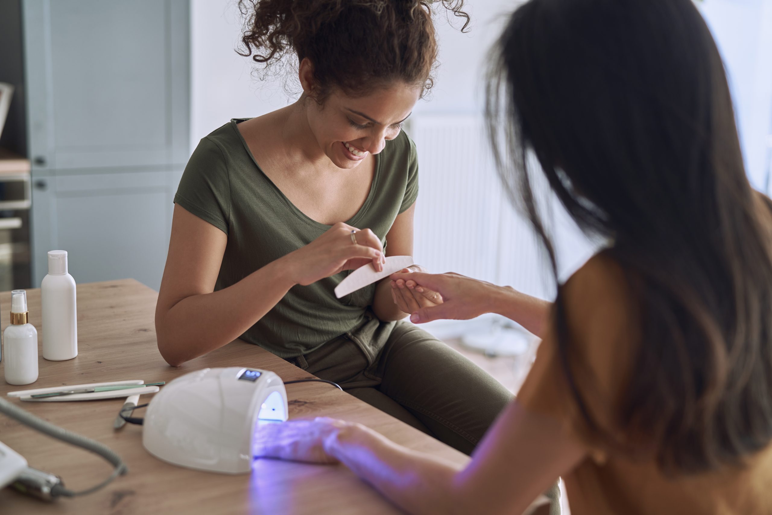 UV Nail Lamps. home manicure. nail polish. Happy women making nail beauty treatments at home