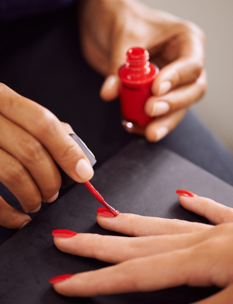 Ravishingly red nails. Closeup of fingernails being painted red. regular polishes.