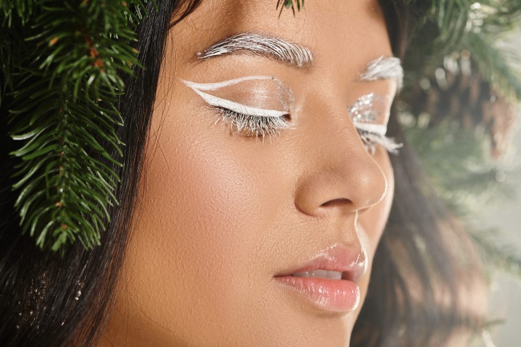 winter beauty, close up of asian woman with white eye makeup and lip balm posing with closed eyes